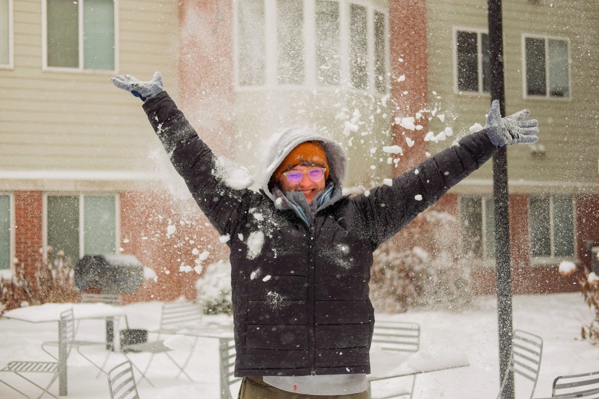 Derek Oberhelman winces with joy as snow hits the top of his head outside of Hull Apartments on Wednesday, February 12, 2025. 

Kylie Arai