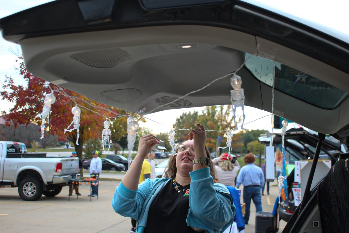 Jordan Lipinski hangs skeleton lights on her car at the Keller Williams Trunk or Treat event in West Des Moines, Iowa, on Thursday October 30, 2025. 

Charlee Heffron