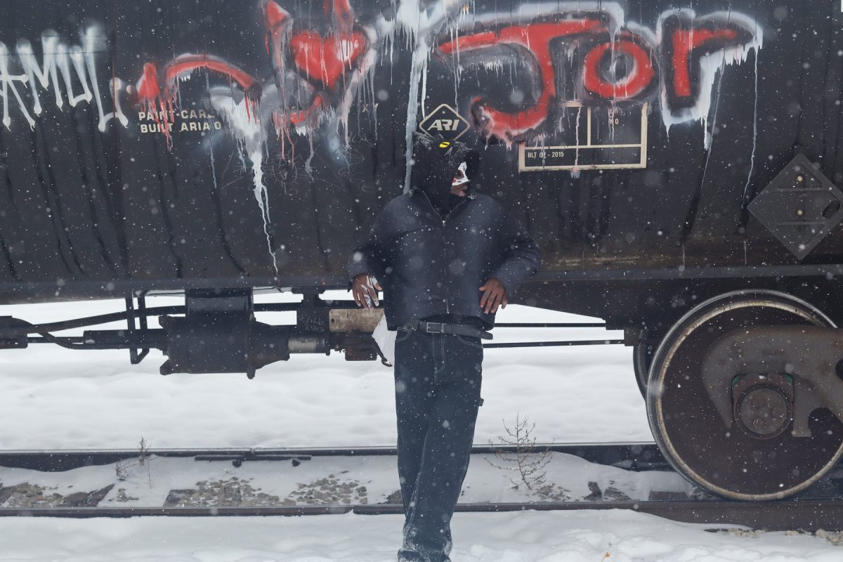 At the train tracks in Des Moines, Iowa Jordan relaxes with his finished art on Saturday, December 1st, 2025.