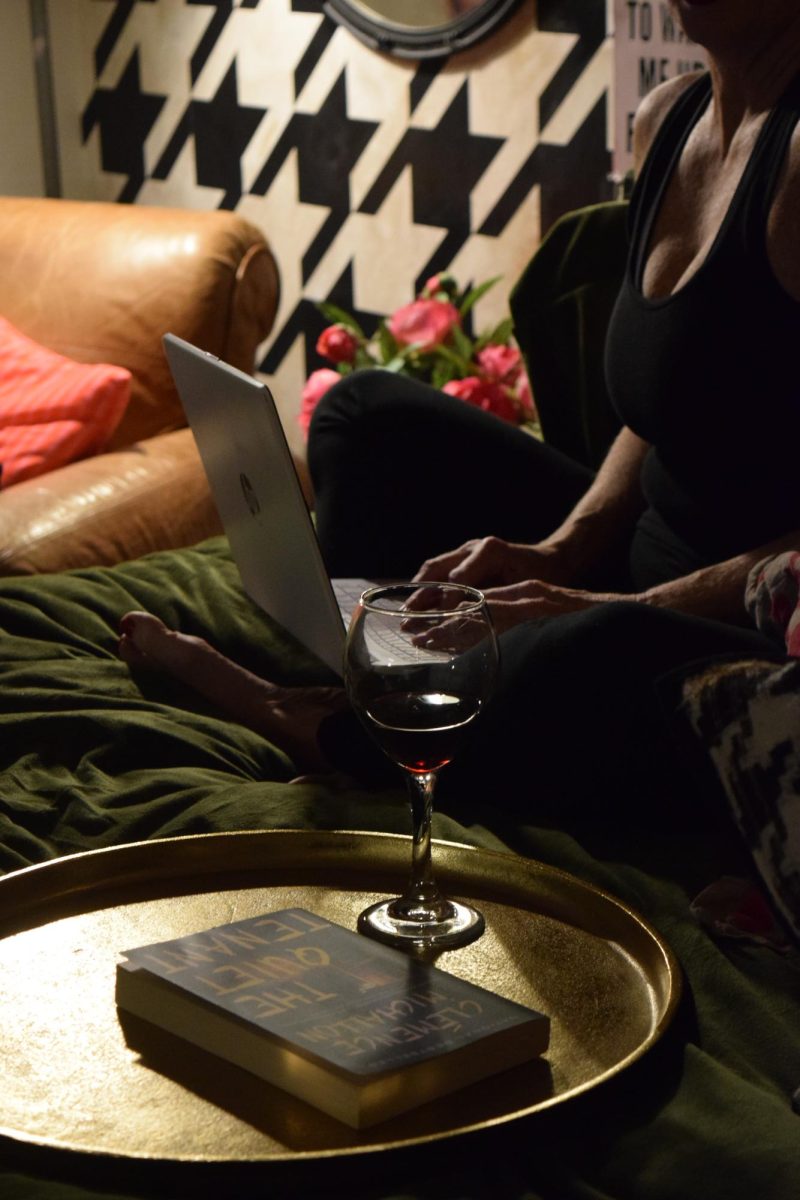 Sommer Walton enjoys a glass of red wine and a book on her bed in her downtown Des Moines loft on November 13, 2025. 