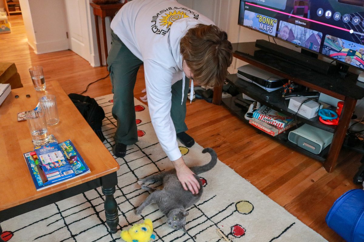 Milos Garton plays with his cat, Willow in his studio apartment in Highland Park, Iowa on Wednesday, November 19, 2025.