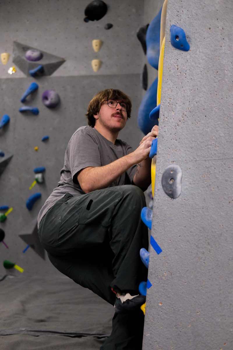 Milos Garton sticks his tongue out in concentration while climbing in Climb Iowa’s East Village location in Des Moines, Iowa on Thursday, November 6, 2025